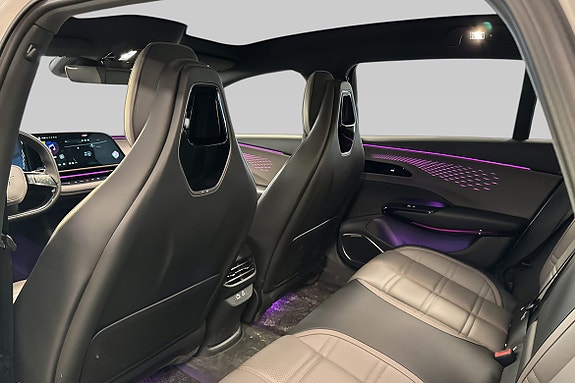 Moderne cockpit med svarte skinnseter og digitalt display.