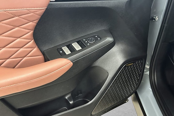 Dørpanel i brunt skinn med elektriske vindus- og speilkontroller.