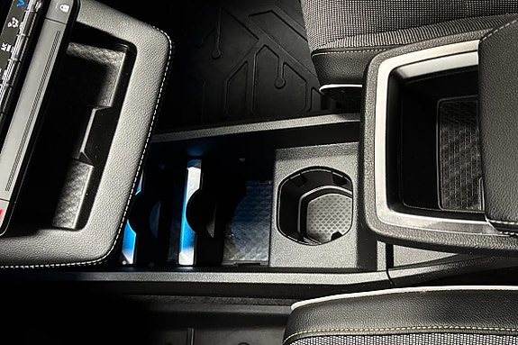 Praktisk midtkonsoll med koppholdere og rom til småting.