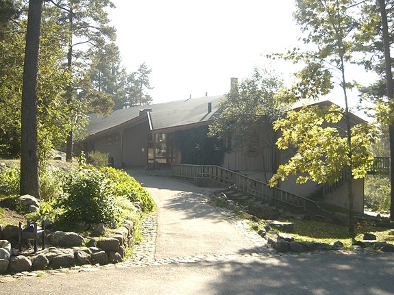 Inngang til barnetrinnets undervisningslokaler og et glimt av skolens tomt.