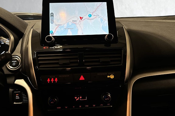 Stor berøringsskjerm med navigasjon og klimakontroll under.