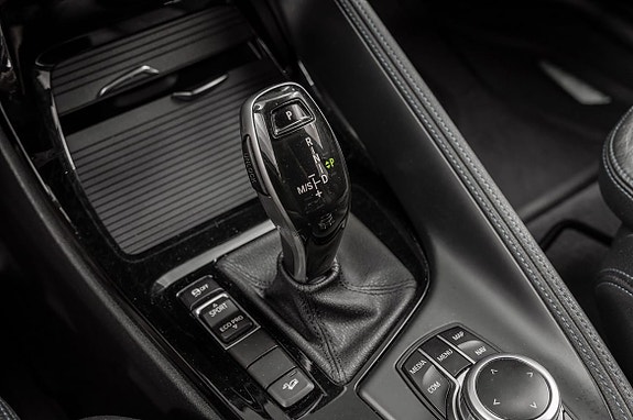 Elegant midtkonsoll med moderne girspak og smarte kontrollknapper.