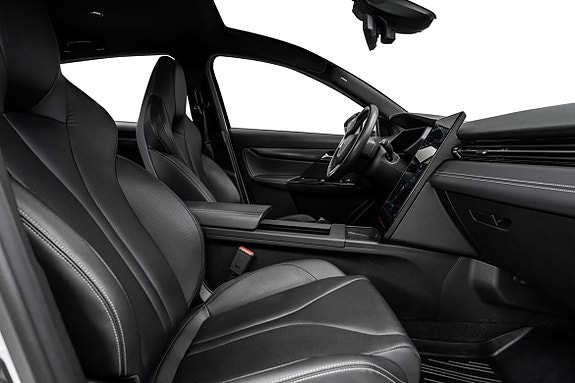 Selvforklarende førermiljø med skinnseter og moderne midtkonsoll.