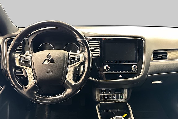 Multifunksjonsratt med Mitsubishi-logo og moderne infotainmentsystem.