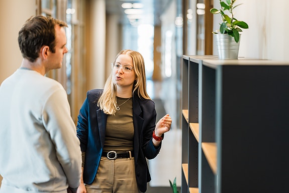 To personer står i gangen og snakker.