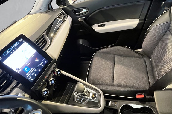 Luksuriøst interiør med skinnseter og digitalt kontrollpanel.