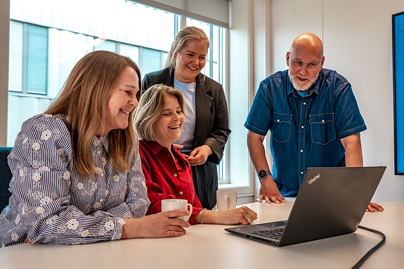 Fire kolleger i møte foran PC
