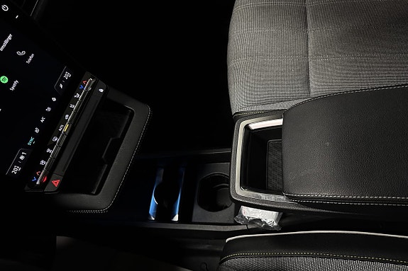 Sentral konsoll med girvelger og praktiske koppholdere for komfort.