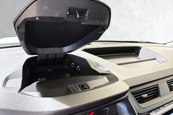 Smart oppbevaringsløsning med USB og luftventilasjon ved dashbord.