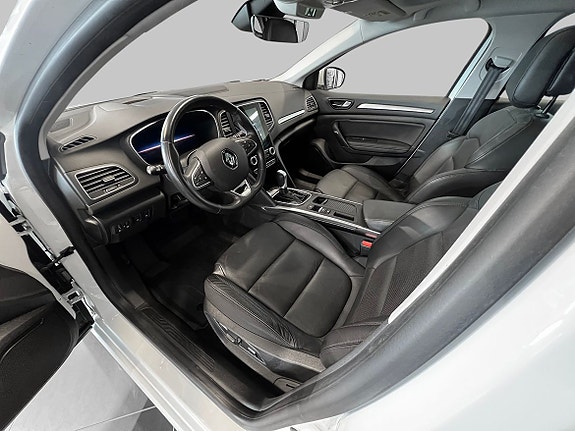 Moderne cockpit med skinnseter og intuitiv touchskjerm for underholdning.
