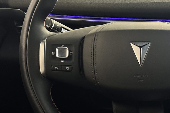 Detaljert ratt i svart skinn med intuitive betjeningsknapper.