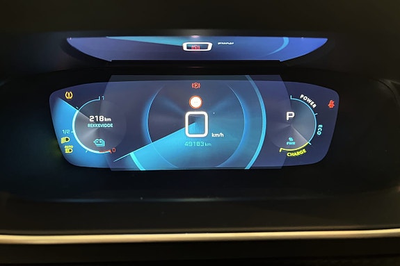 Digitalt instrumentpanel med rekkeviddeindikator og varslingssystemer.