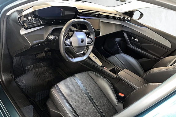 Moderne cockpit med digitale skjermer og komfortable del-skinnseter.