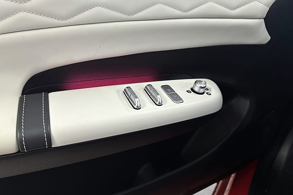 Dørpanel i hvitt skinn med stilrene kontroller for vindu.