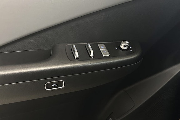 Stilfull dørpanel med elektriske vinduskontroller og moderne håndtak.