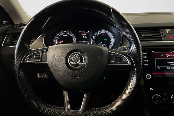 Moderne ratt med kontroller og digital skjerm for kjøredata.