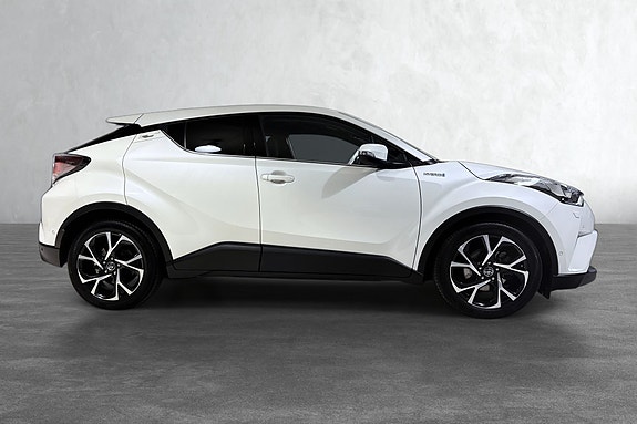 Sporty sideprofil med svart kontrast og elegante aluminiumshjul.