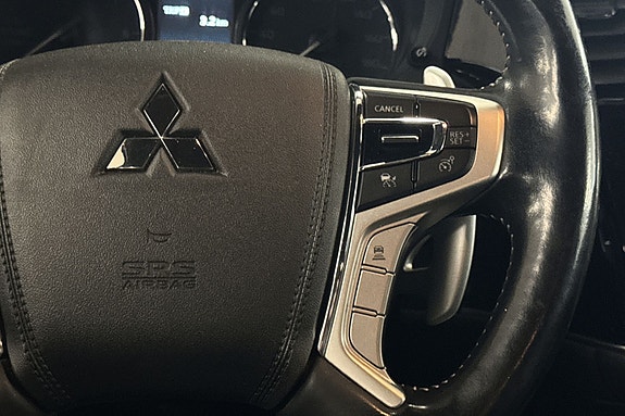 Ergonomisk ratt med Mitsubishi-logo og praktiske kontrollknapper.