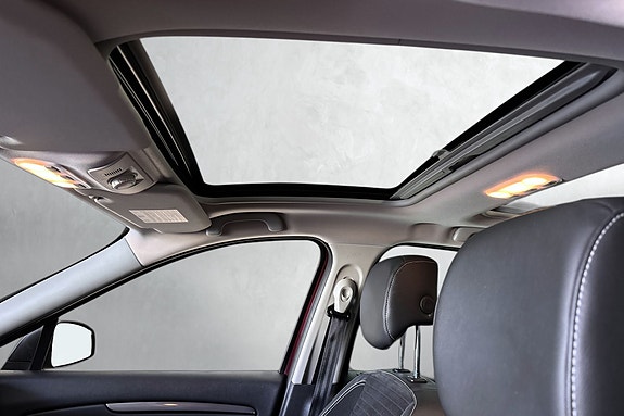 Luksuriøst interiør med panoramasoltak gir romslig følelse inne.