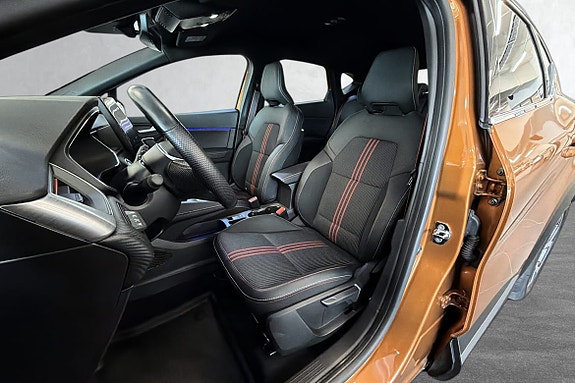 Sporty interiør med røde detaljer og komfortable seter.
