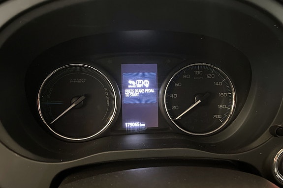 Oversiktlig instrumentpanel med analoge målere og digital skjerm.