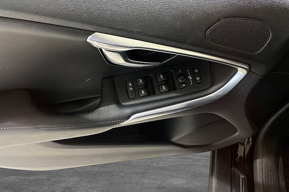 Dørpanel med moderne vindusregulering og elegante chrome detaljer.