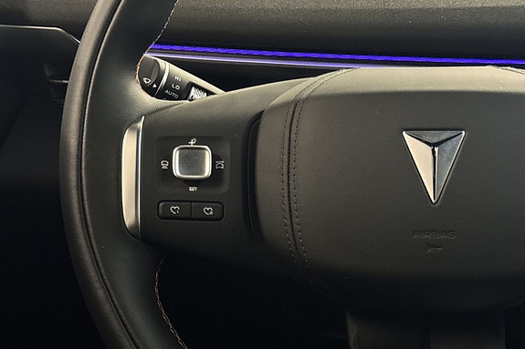 Detaljert ratt i svart skinn med intuitive betjeningsknapper.