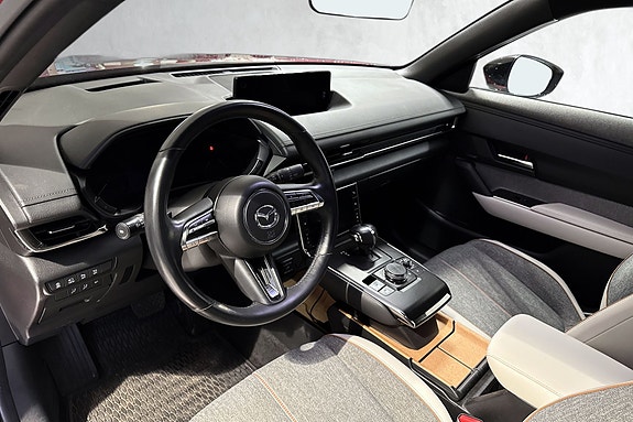 Teknologisk moderne cockpit med digital infoskjerm og rattkontroller.