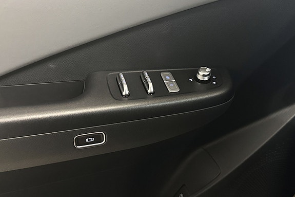 Stilfull dørpanel med elektriske vinduskontroller og moderne håndtak.