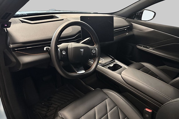 Moderne cockpit med stor berøringsskjerm og skinninteriør.