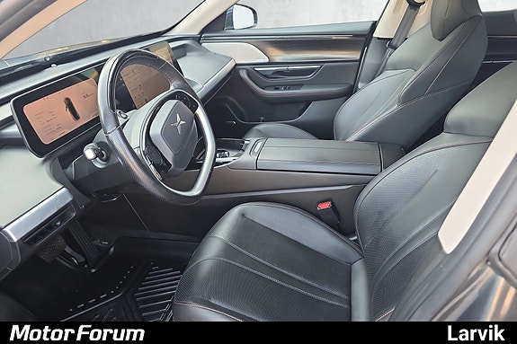 Moderne cockpit med digital skjerm og komfortable skinnseter.