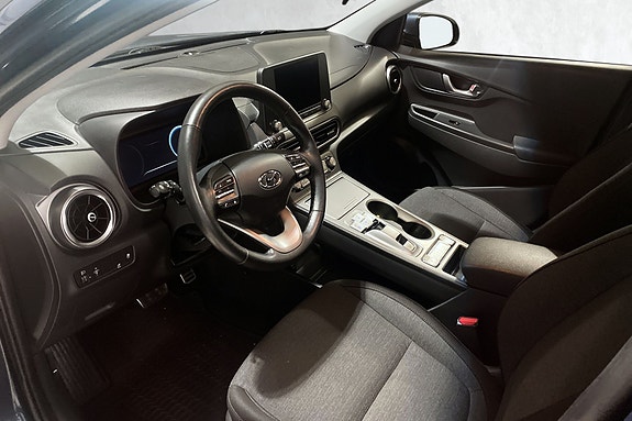 Moderne cockpit med touchskjerm og komfortable tekstilseter.