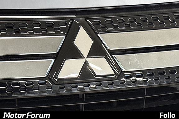 Kraftfull front med Mitsubishi emblem og skinnende kromramme.