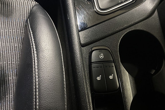Setejustering med elektriske kontroller og praktisk koppholder.