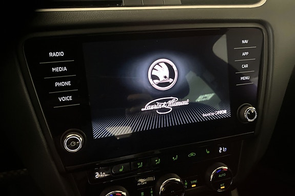 Berøringsskjerm med Skoda-logo og brukervennlige knapper rundt.