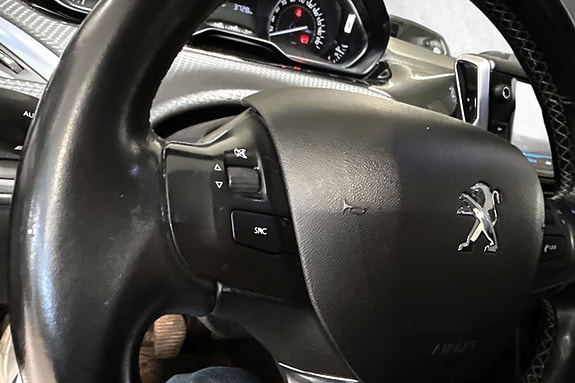 Ratt med praktiske kontrollknapper og tydelig Peugeot-logo.