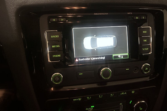 Moderne infotainmentskjerm med parkeringsassistent for trygg manøvrering.