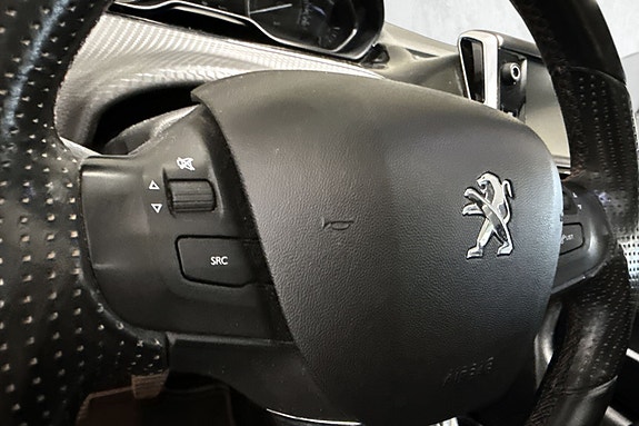 Multifunksjonsratt med integrerte knapper og tydelig Peugeot-logo.