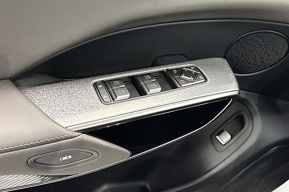 Detaljerte paneler med vinduskontroller og moderne materialvalg.