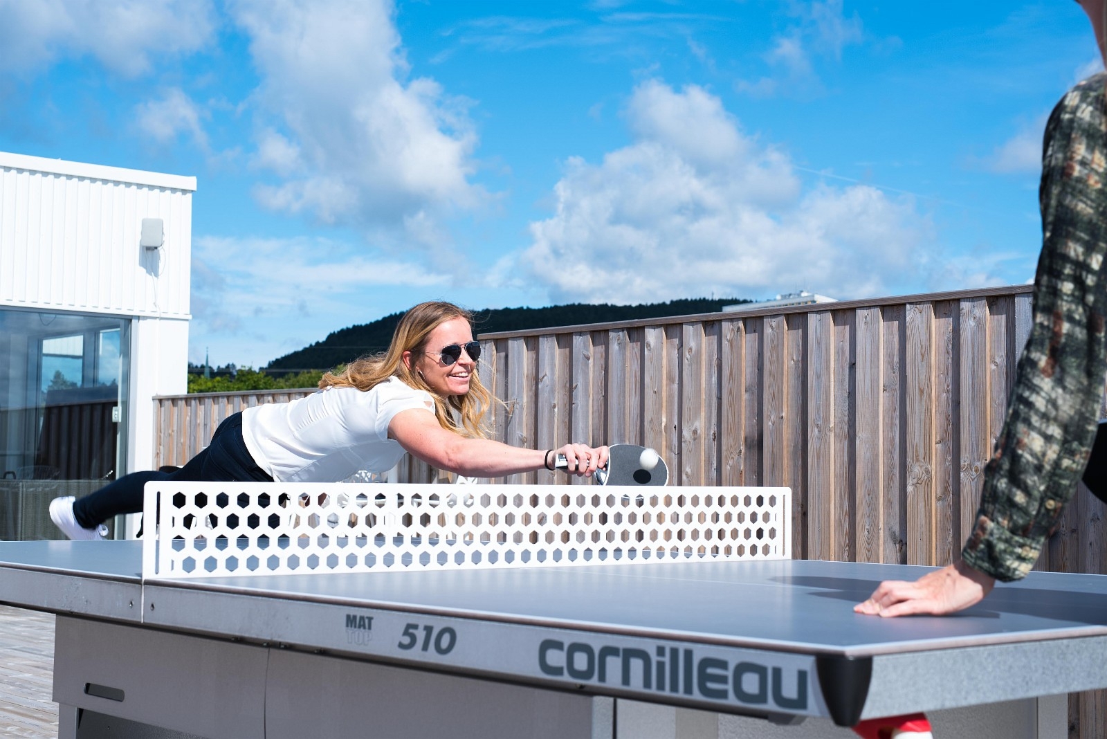 Cathrine tar en runde bordtennis på vår takterrasse